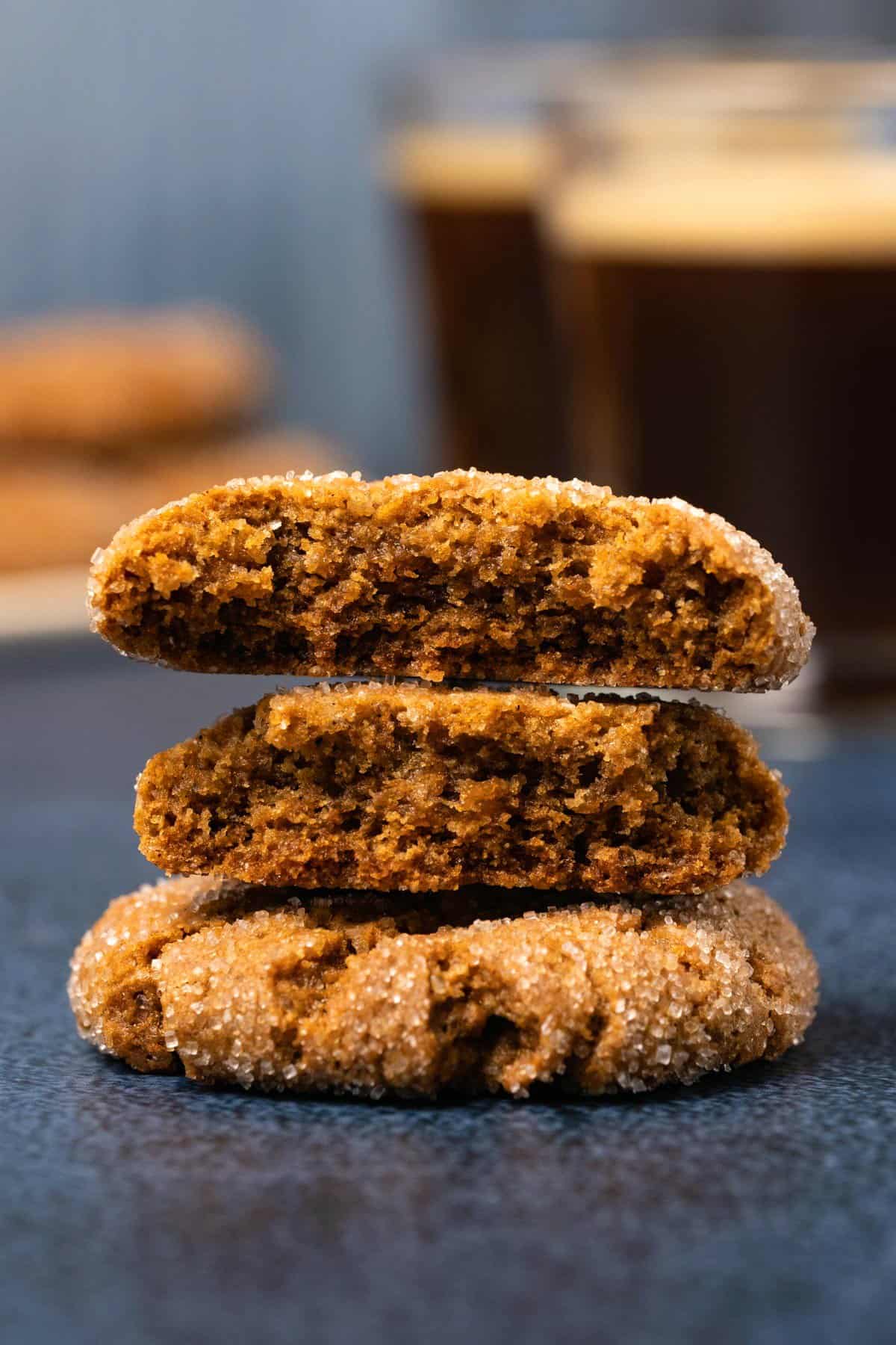 Vegan ginger cookies in a stack with the top cookie broken in half. 