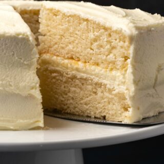 Vegan white cake on a white cake stand.