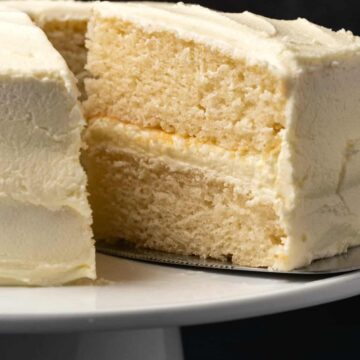 Vegan white cake on a white cake stand.