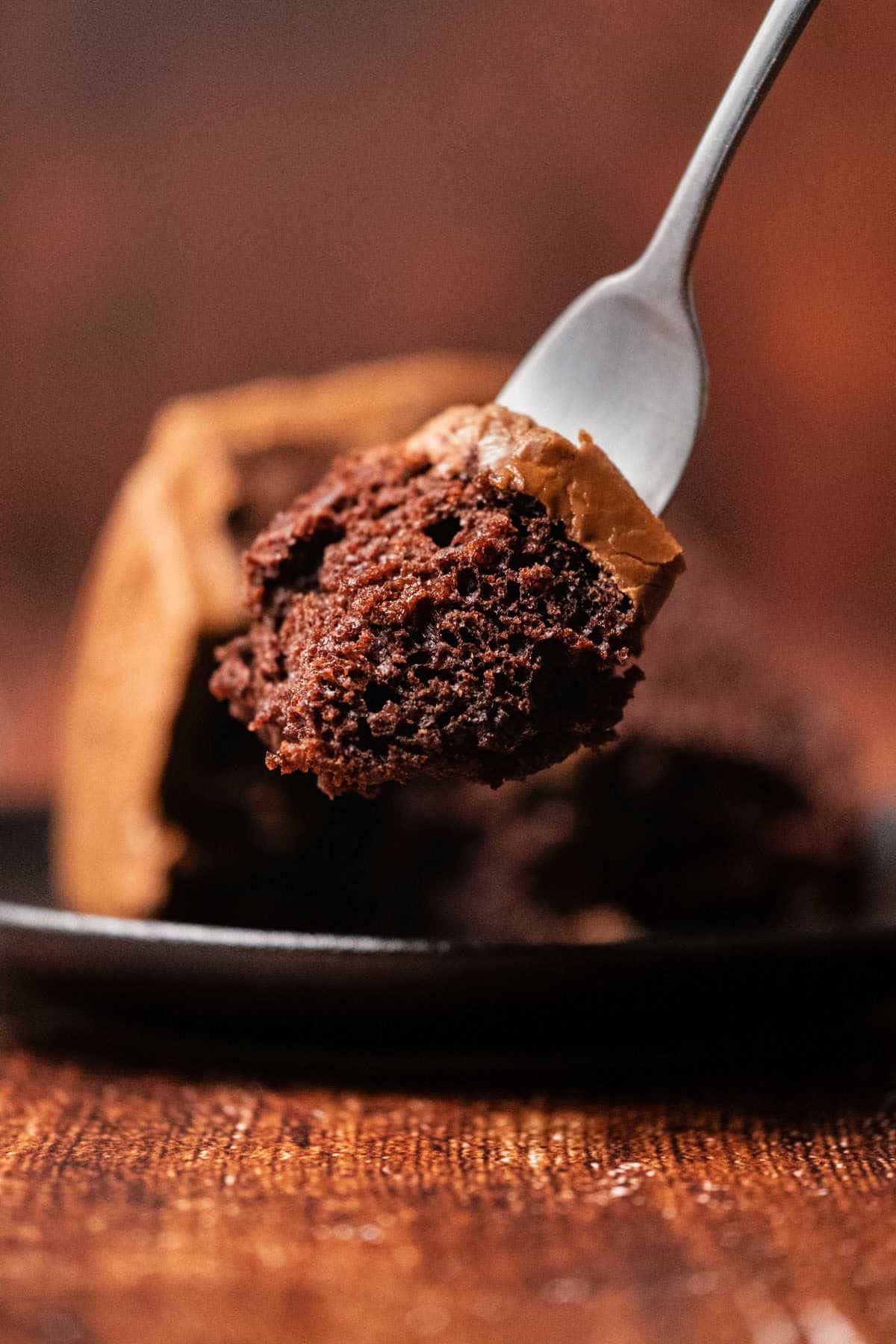 Forkful of chocolate cake with frosting. 