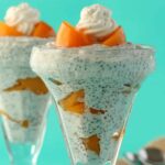 Chia pudding layered with peaches in a sundae glass.