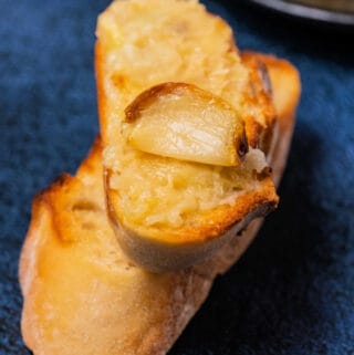 A clove of roast garlic on a slice of toast.
