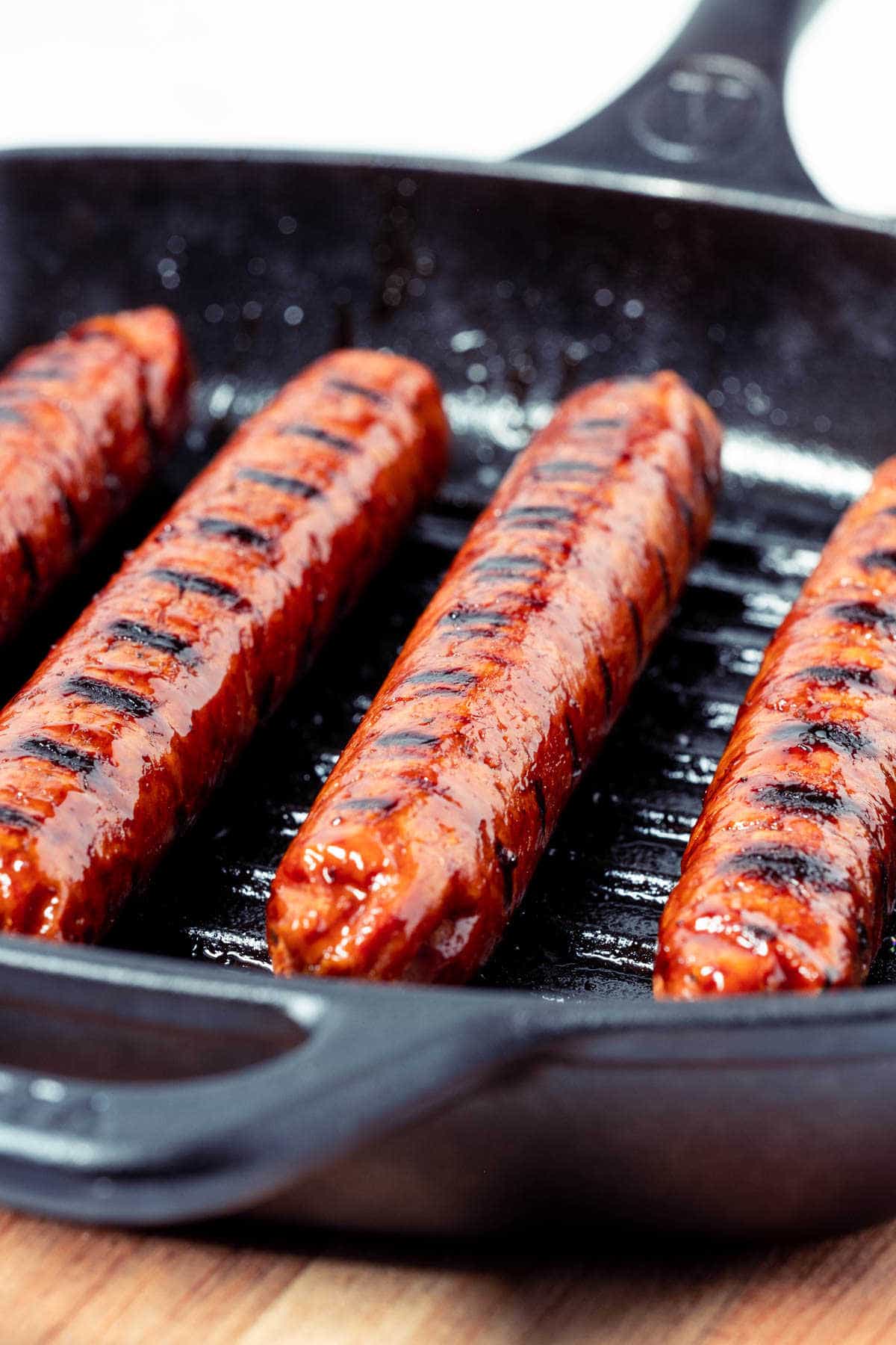 Close up photo of vegan sausages in a grill pan.