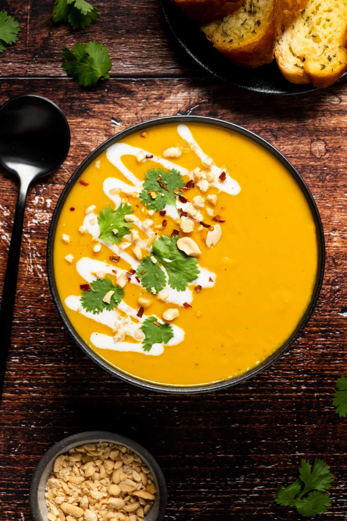 Thai butternut squash soup in a bowl topped with crushed peanuts and fresh cilantro.