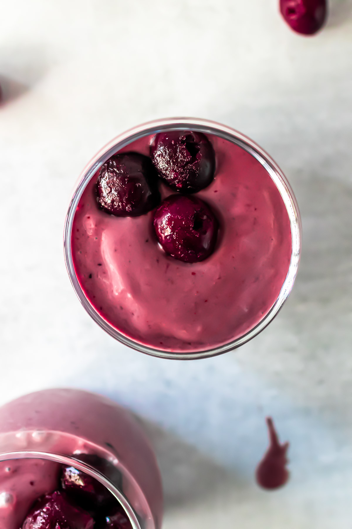 Overhead photo of smoothie topped with whole cherries.