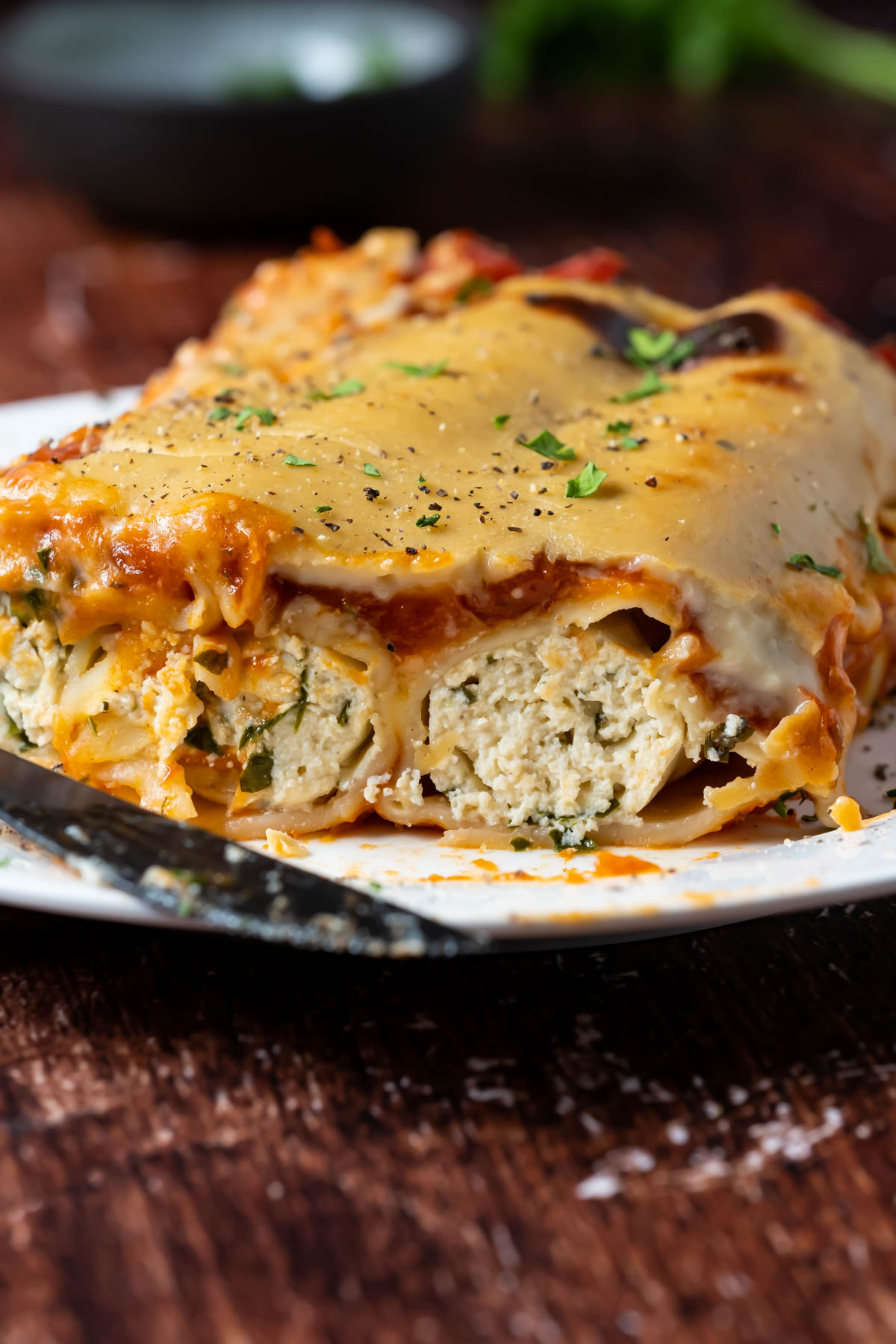 Vegan cannelloni with fresh chopped parsley on a white plate.