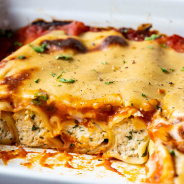 Sliced vegan cannelloni in a white baking dish.