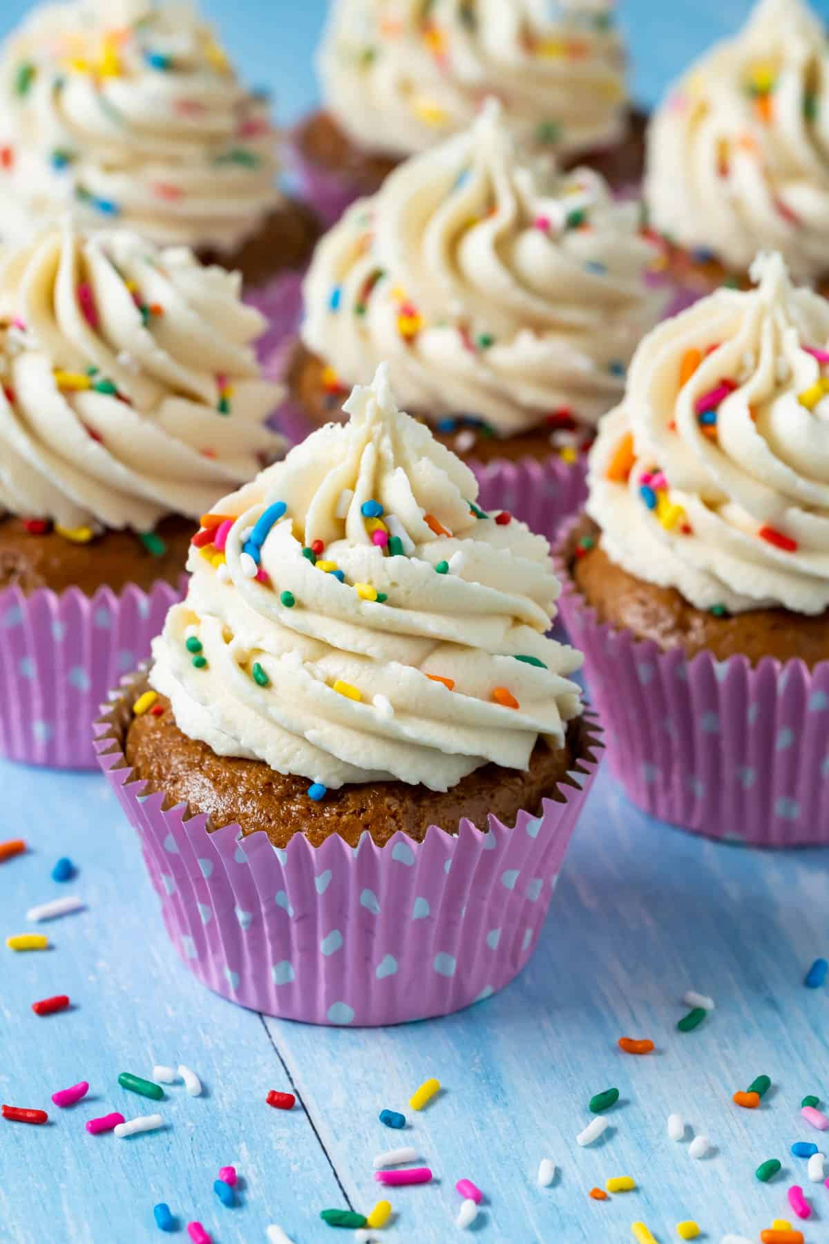 Vegan gluten free vanilla cupcakes topped with frosting and sprinkles. 