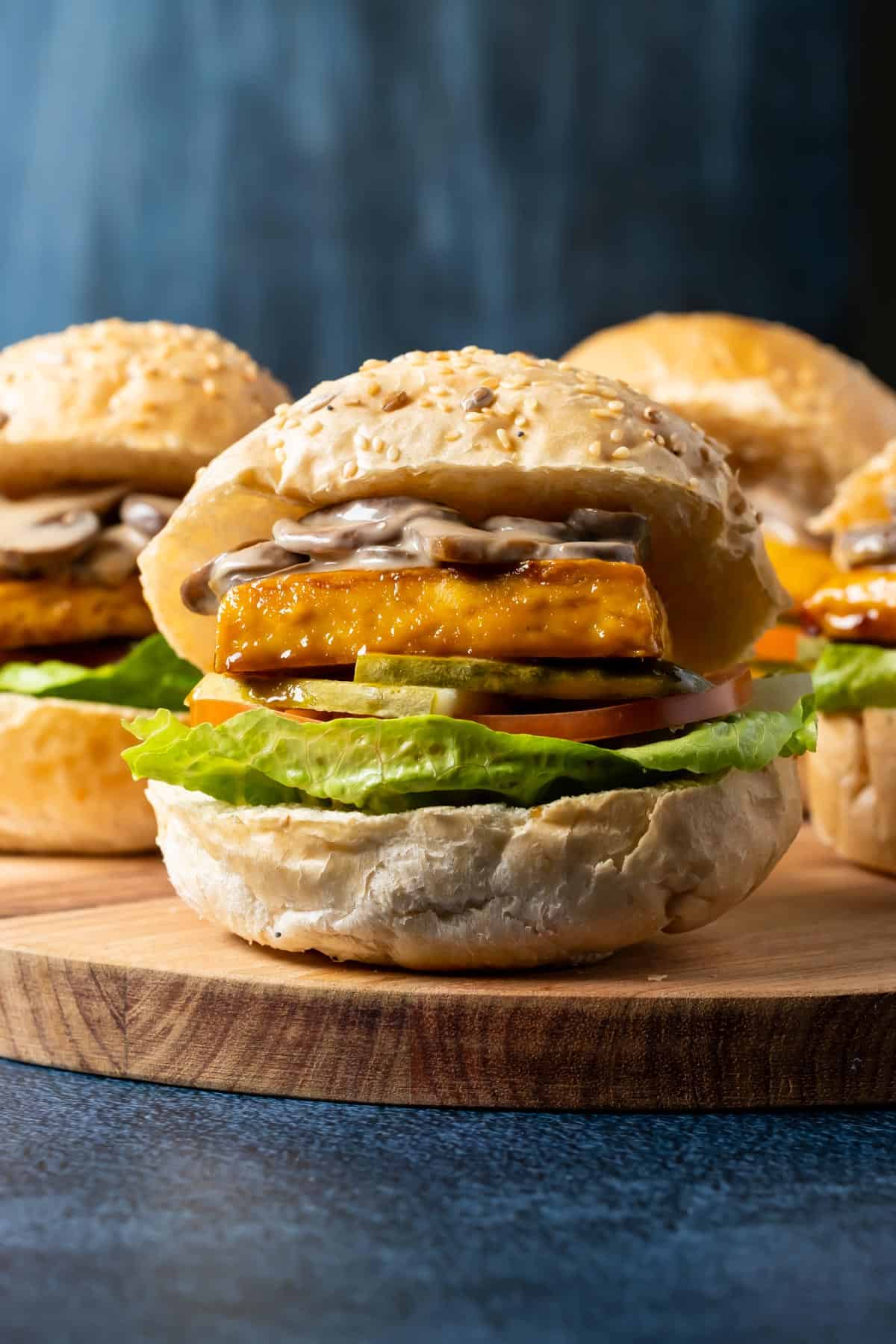 Tofu burgers on a wooden board.