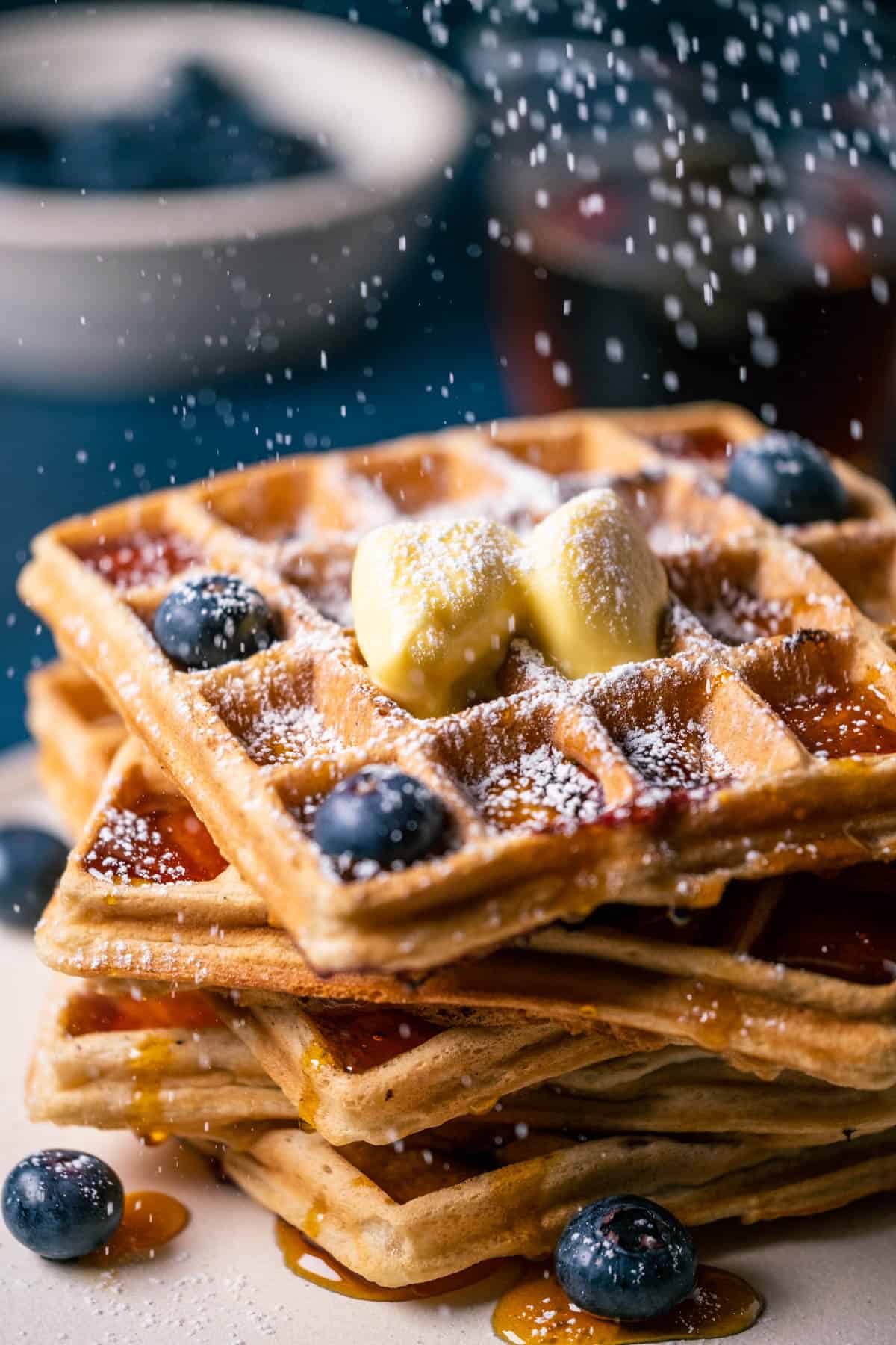 Stack of blueberry waffles on a white plate. 