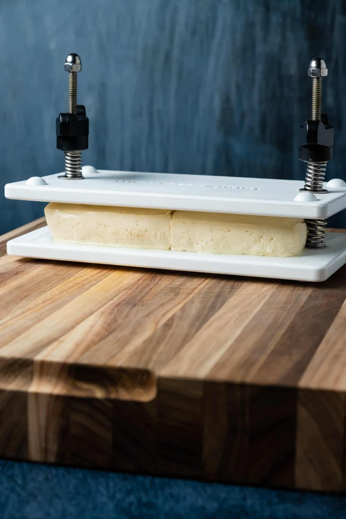Tofu pressing in a tofu press. 
