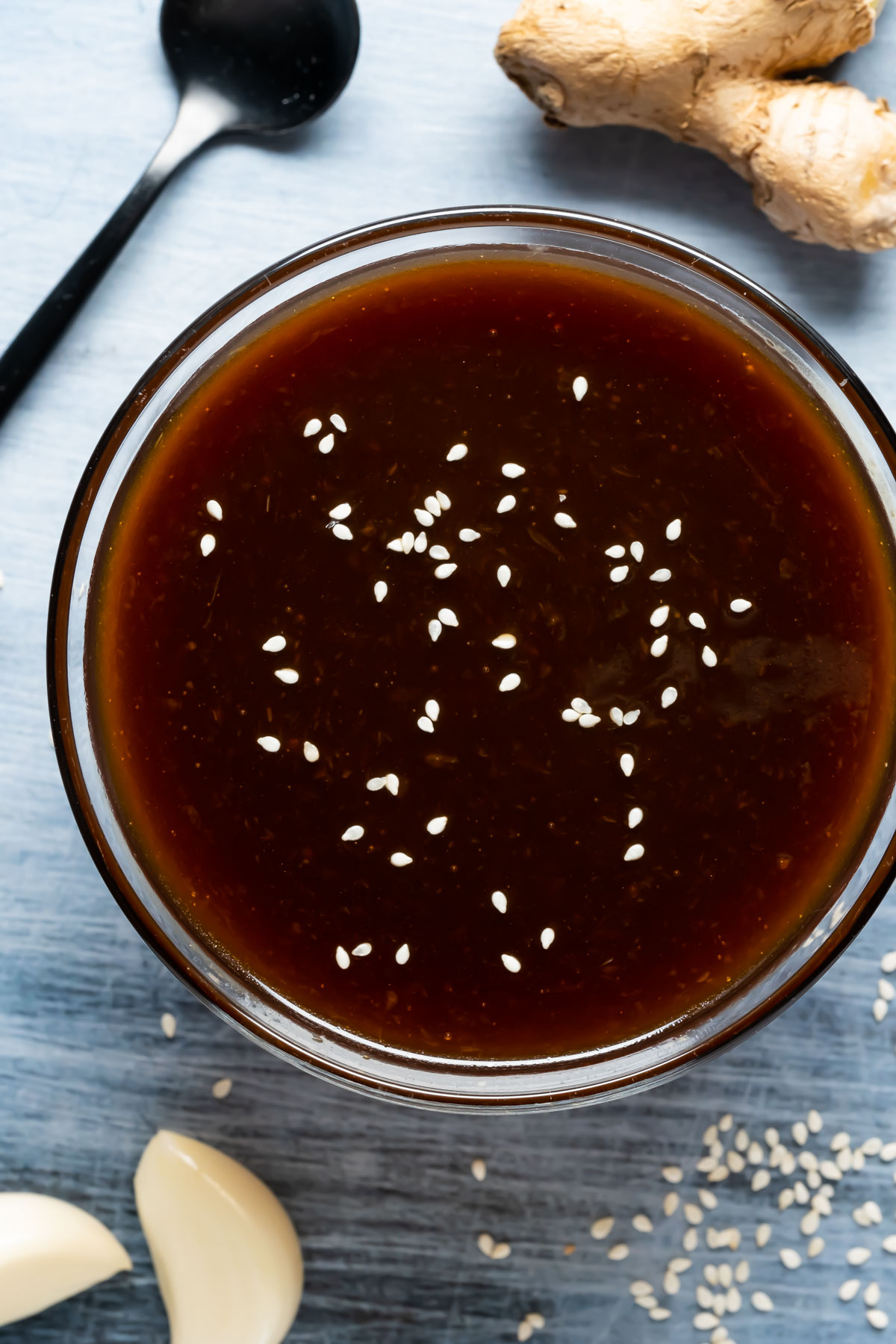 Vegan teriyaki sauce topped with sesame seeds in a glass dish.