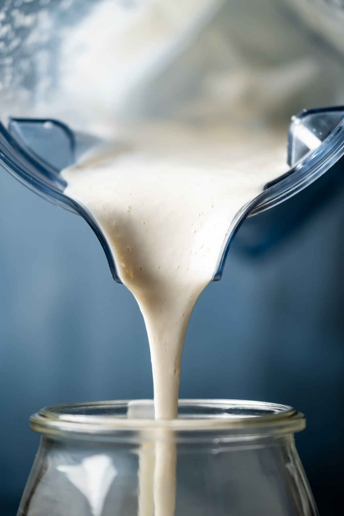 Vegan heavy cream substitute pouring into a glass jar.