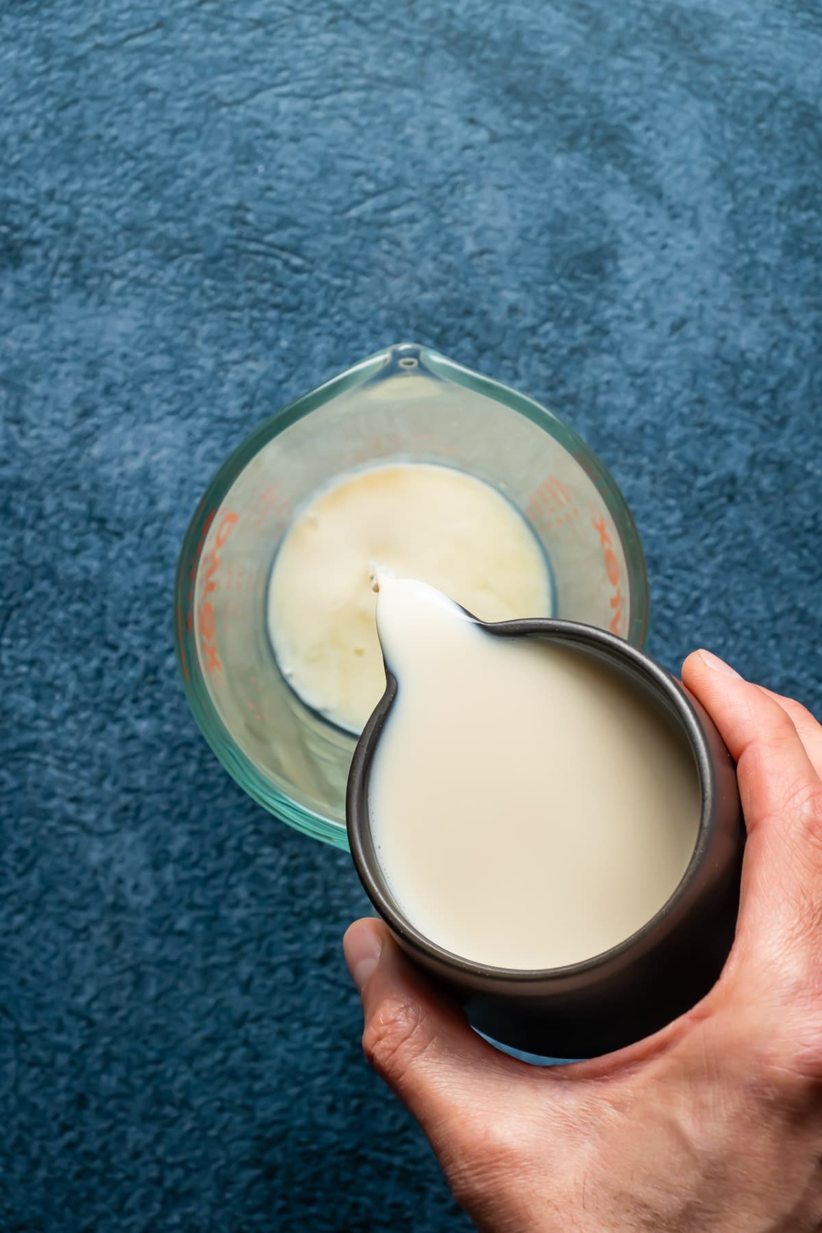 Pouring soy milk into a glass jug.