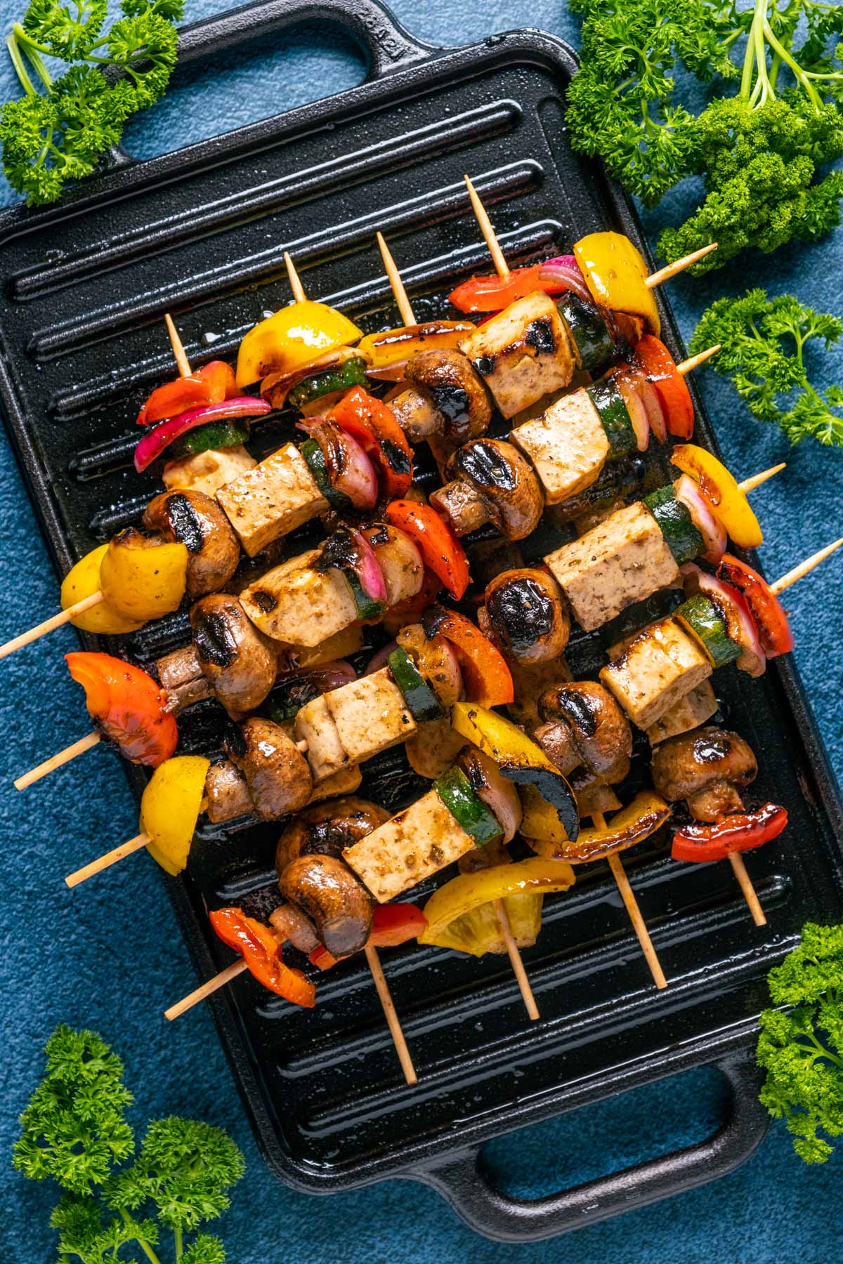 Vegan kebabs stacked up on a grill. 