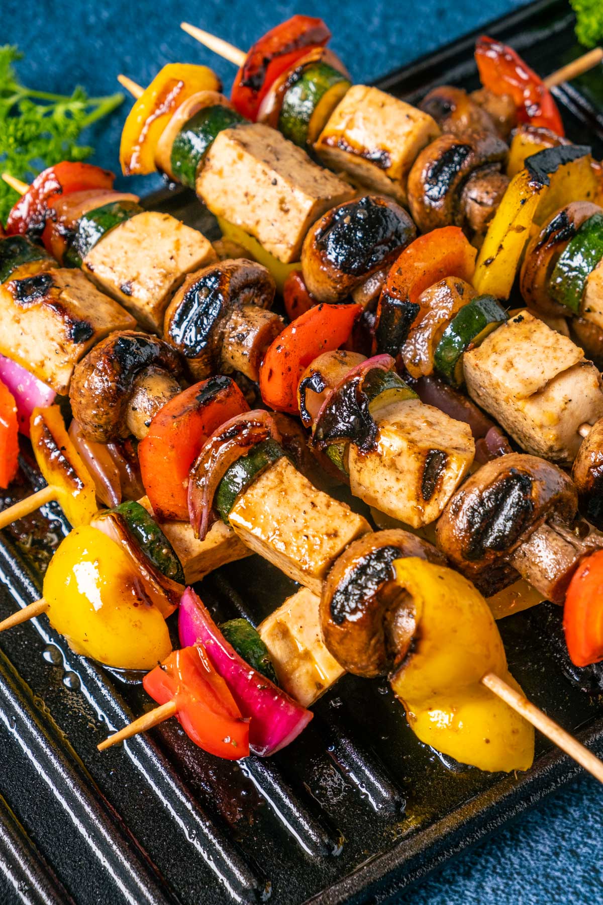 Vegan kebabs stacked up on a grill.