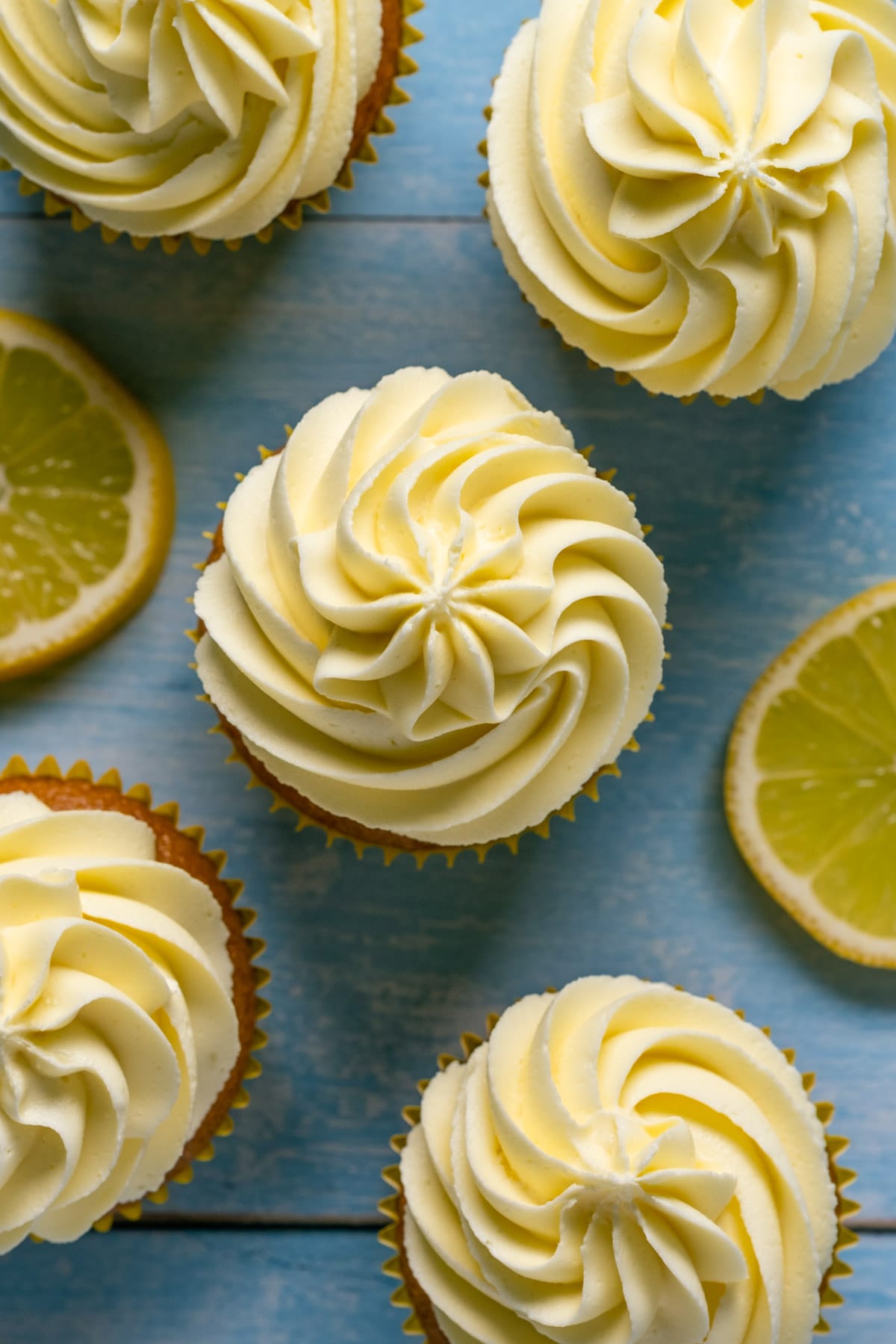 Overhead photo of vegan cupcakes topped with a vegan lemon buttercream frosting. 