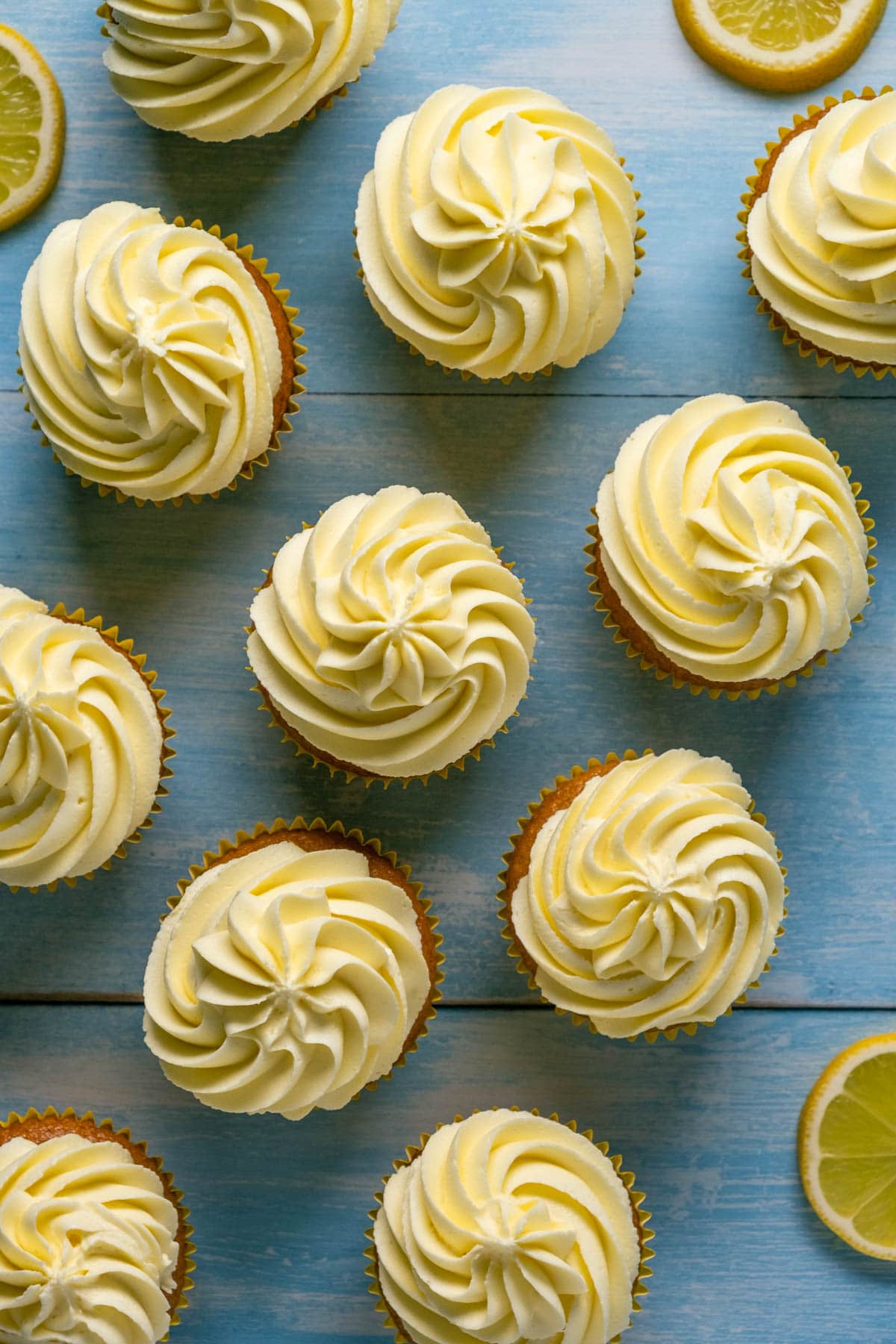 Overhead photo of vegan cupcakes topped with a vegan lemon buttercream frosting.