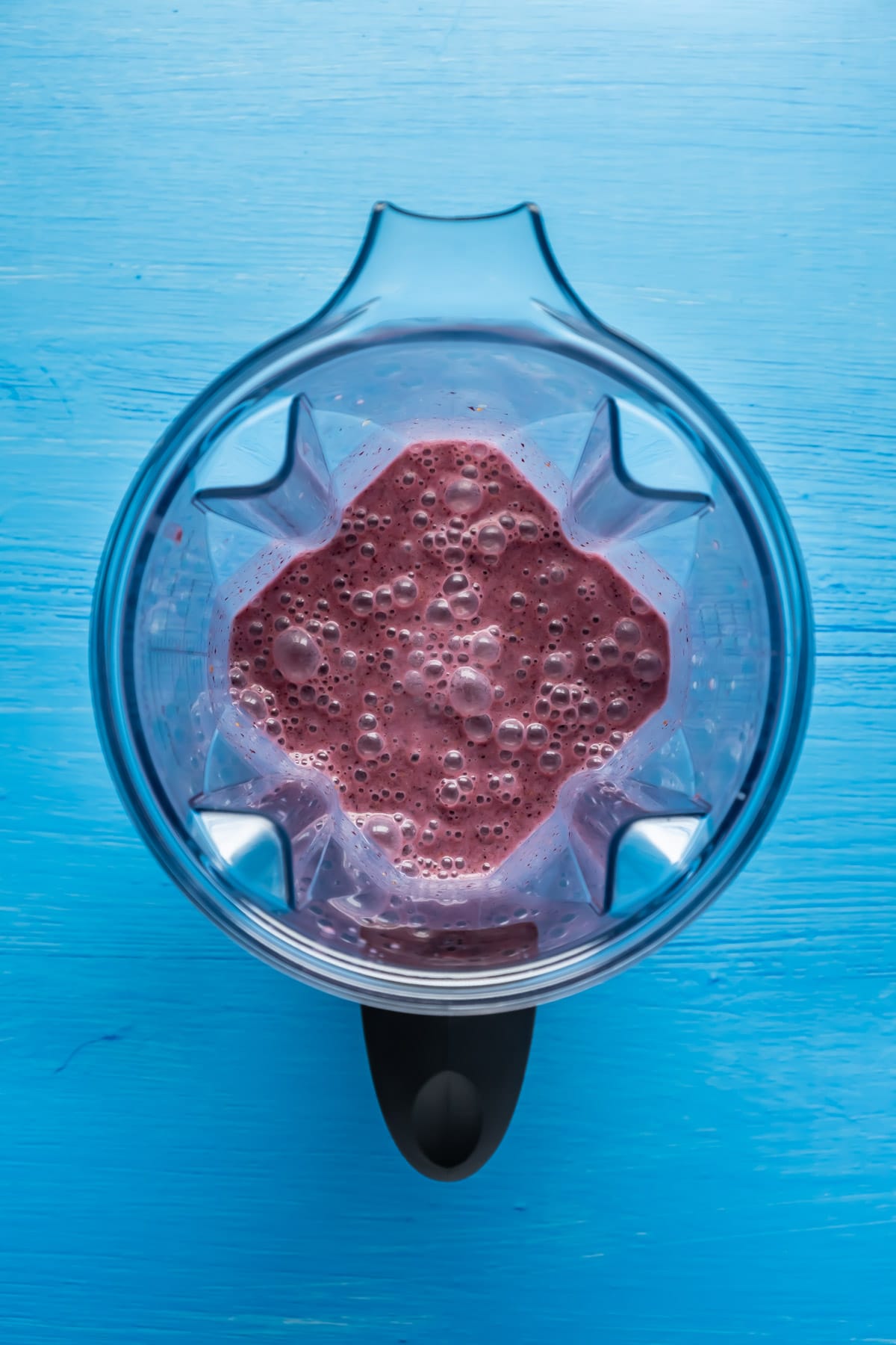 Blended blueberry smoothie in a blender jug.