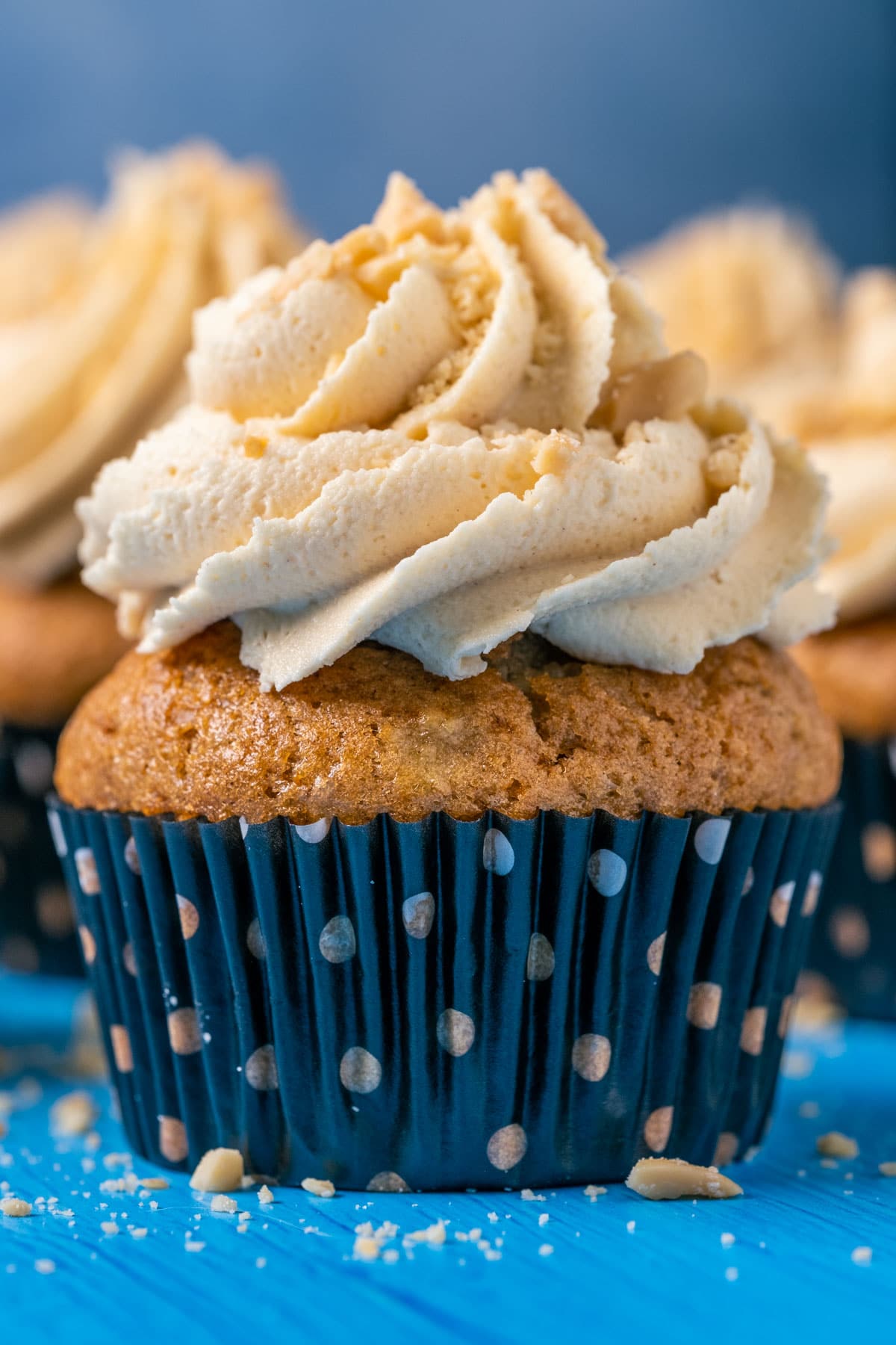 Vegan banana cupcakes topped with peanut butter frosting and crushed peanuts.