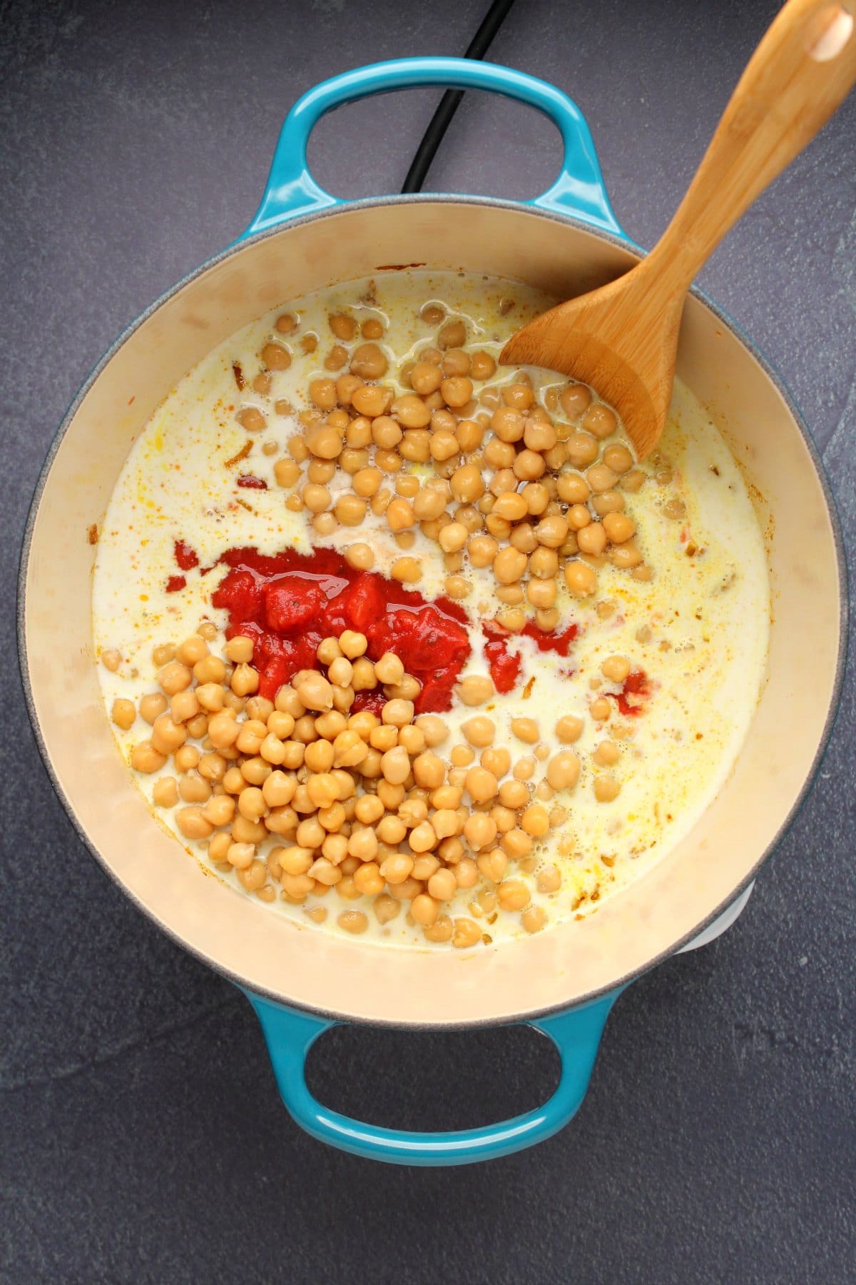 Chickpeas, chopped tomato and coconut milk added to pot.