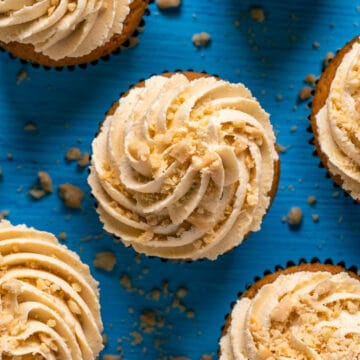Cupcakes topped with peanut butter frosting and crushed peanuts.
