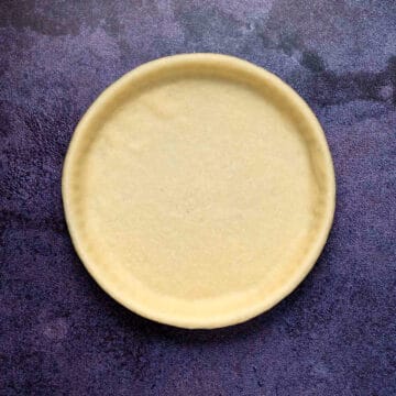 Unbaked pie crust in a glass dish.