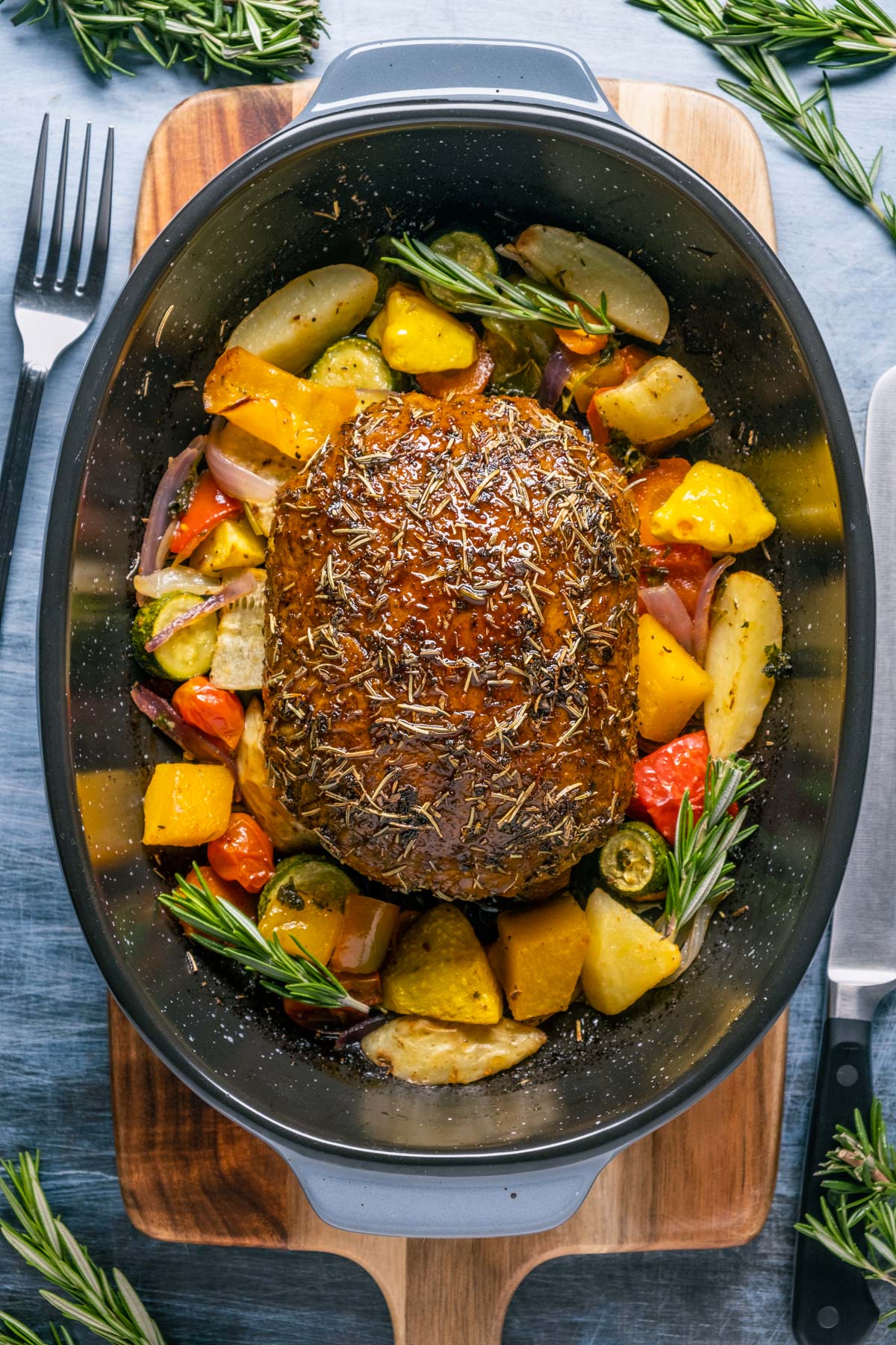 Vegan turkey roast with roasted vegetables in a roasting pan.