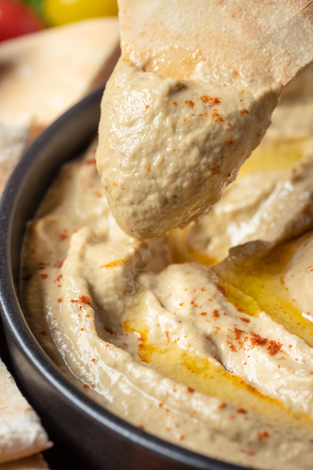 Pita bread dipped into a bowl of baba ganoush.