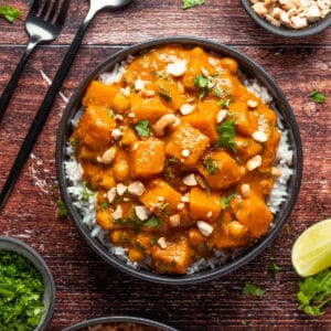 Veganes Butternusskürbis-Curry in einer schwarzen Schüssel.