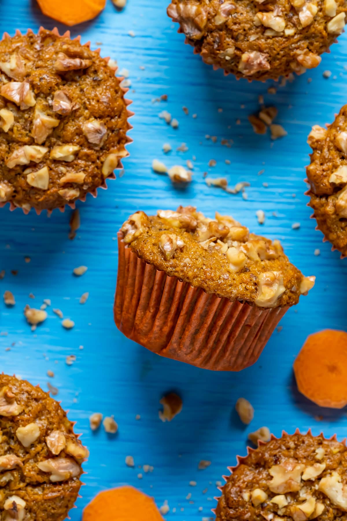 Vegan carrot muffins topped with chopped walnuts.