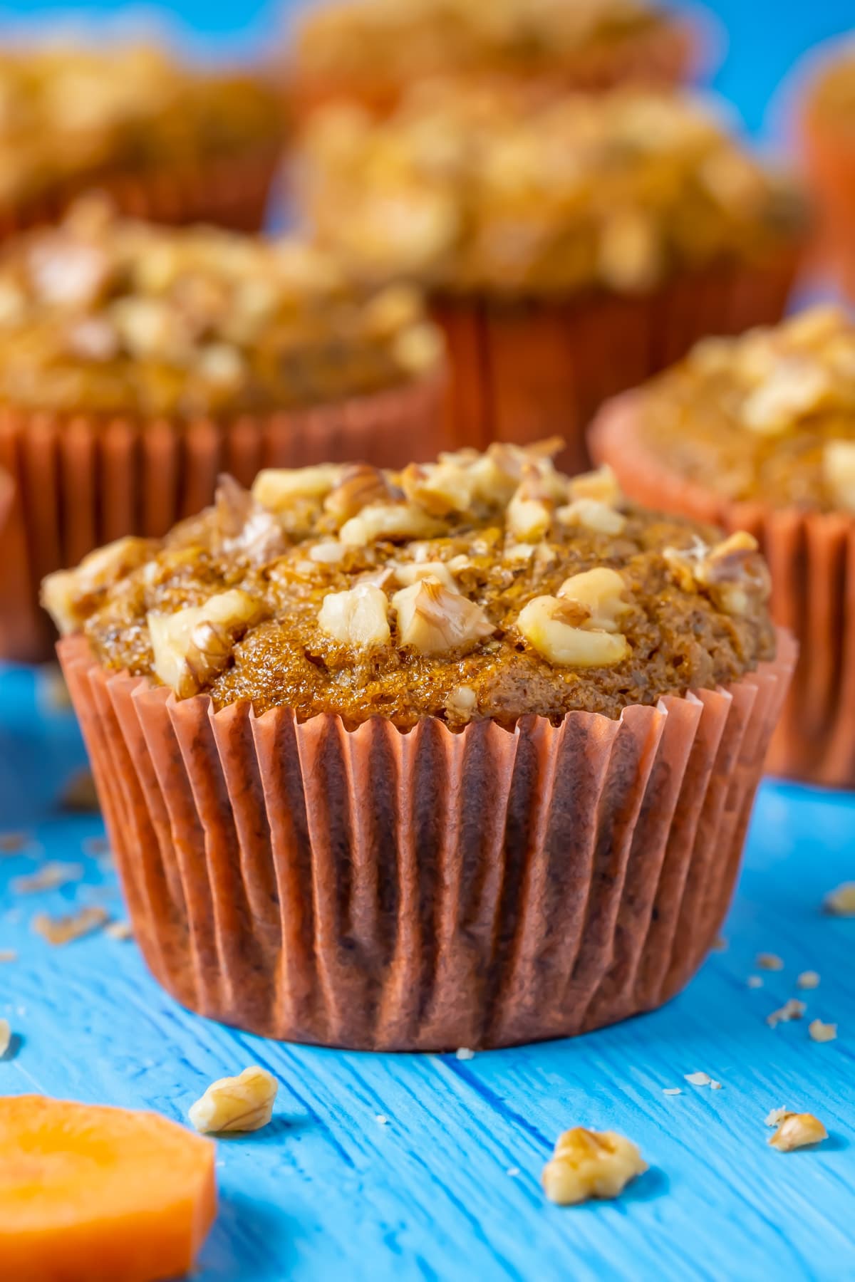 Vegan carrot muffins topped with chopped walnuts. 