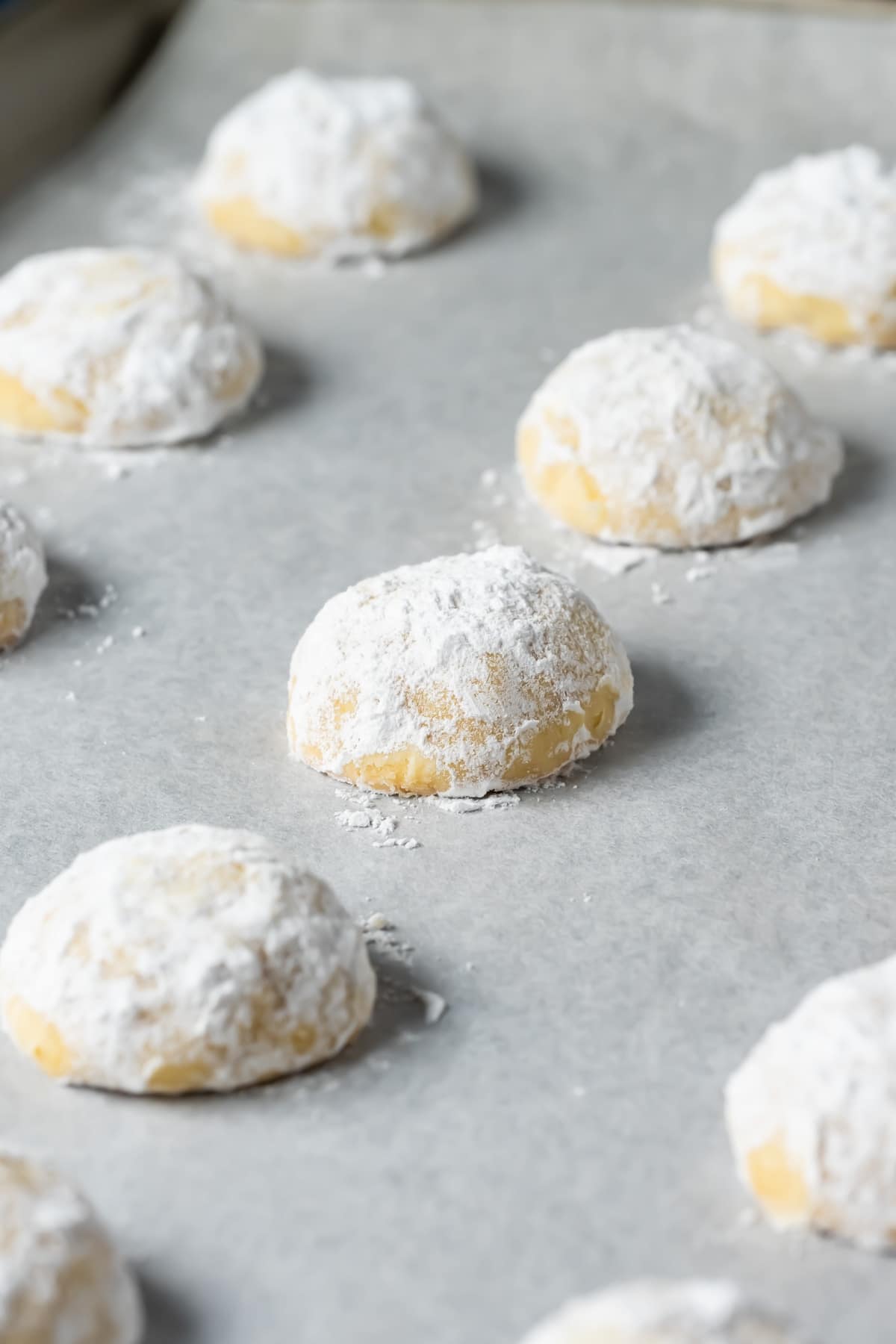 Vegan snowball cookies on a parchment lined baking tray.