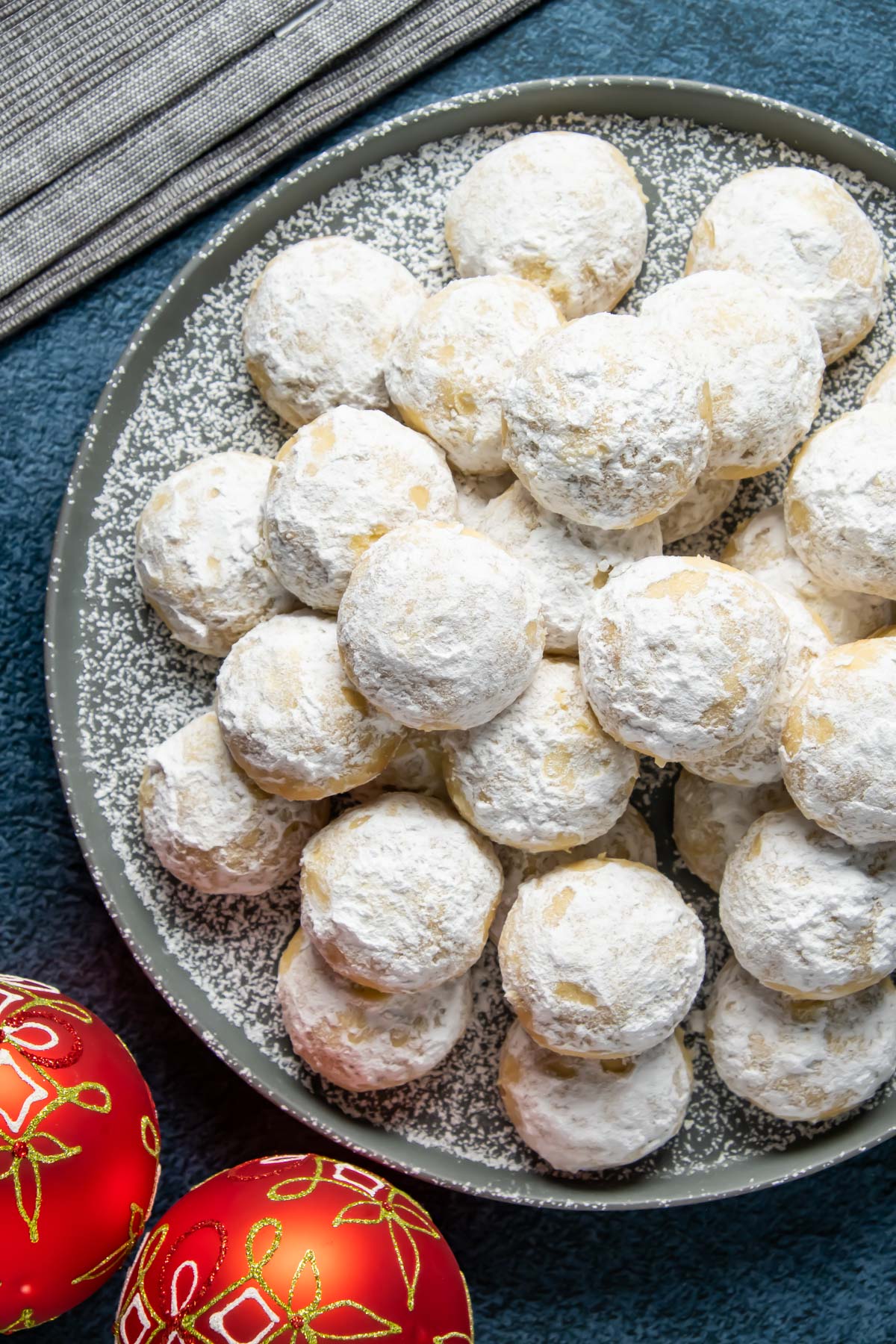 Vegan snowball cookies stacked up on a plate. 