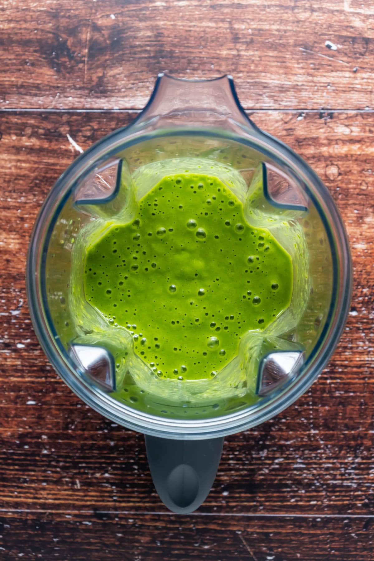 Blended green smoothie in a blender jug.
