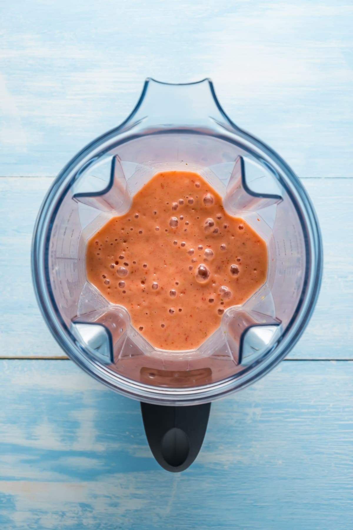 Blended strawberry mango smoothie in a blender jug.