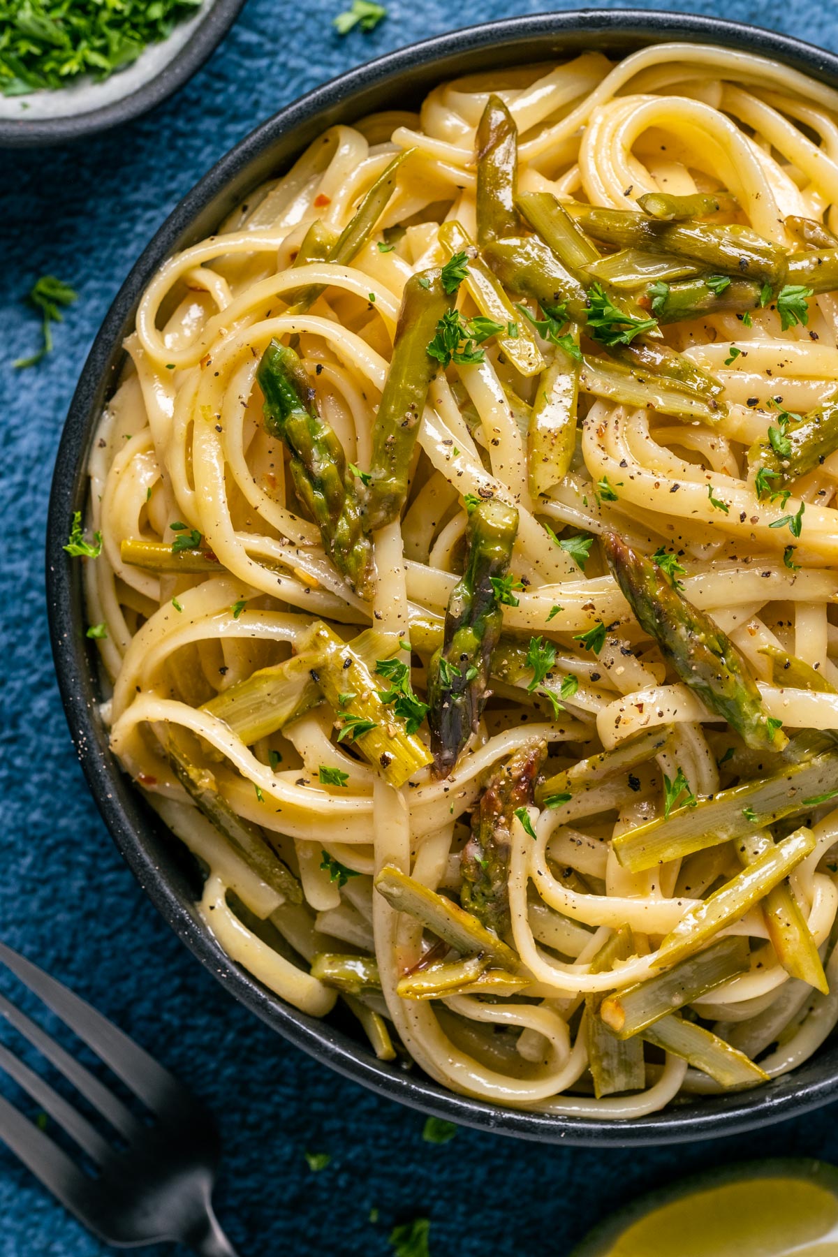 Vegan asparagus pasta in a black bowl.