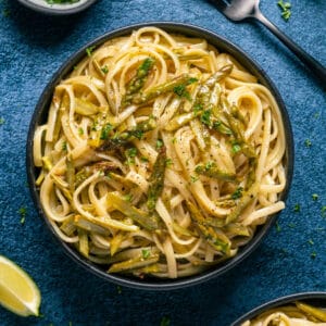 Vegan asparagus pasta in a black bowl.