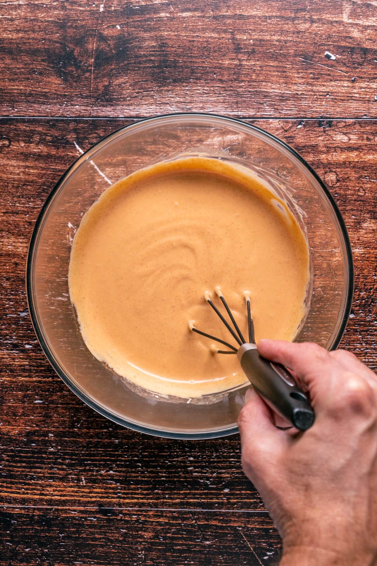 Yum yum sauce in a glass bowl with a whisk.
