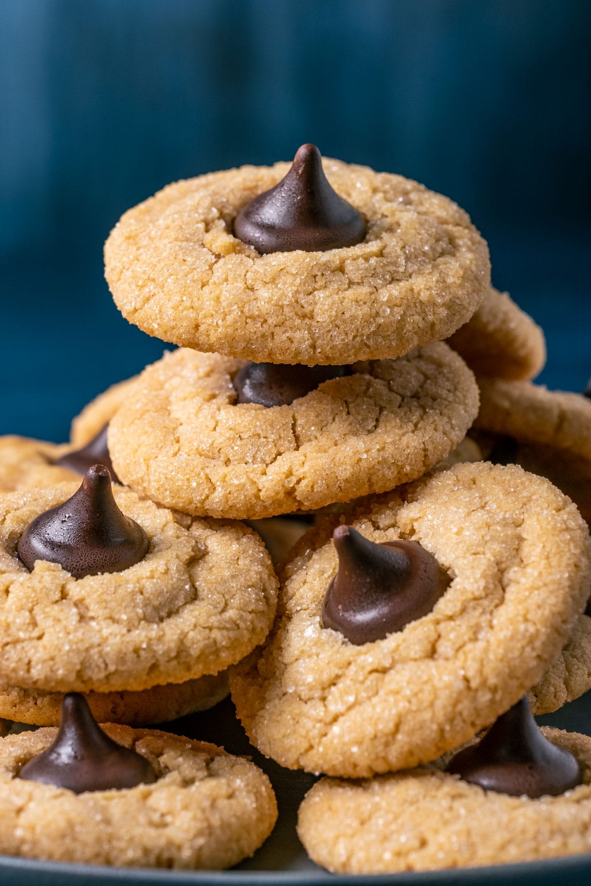 Vegan peanut butter blossoms stacked up on a gray plate.