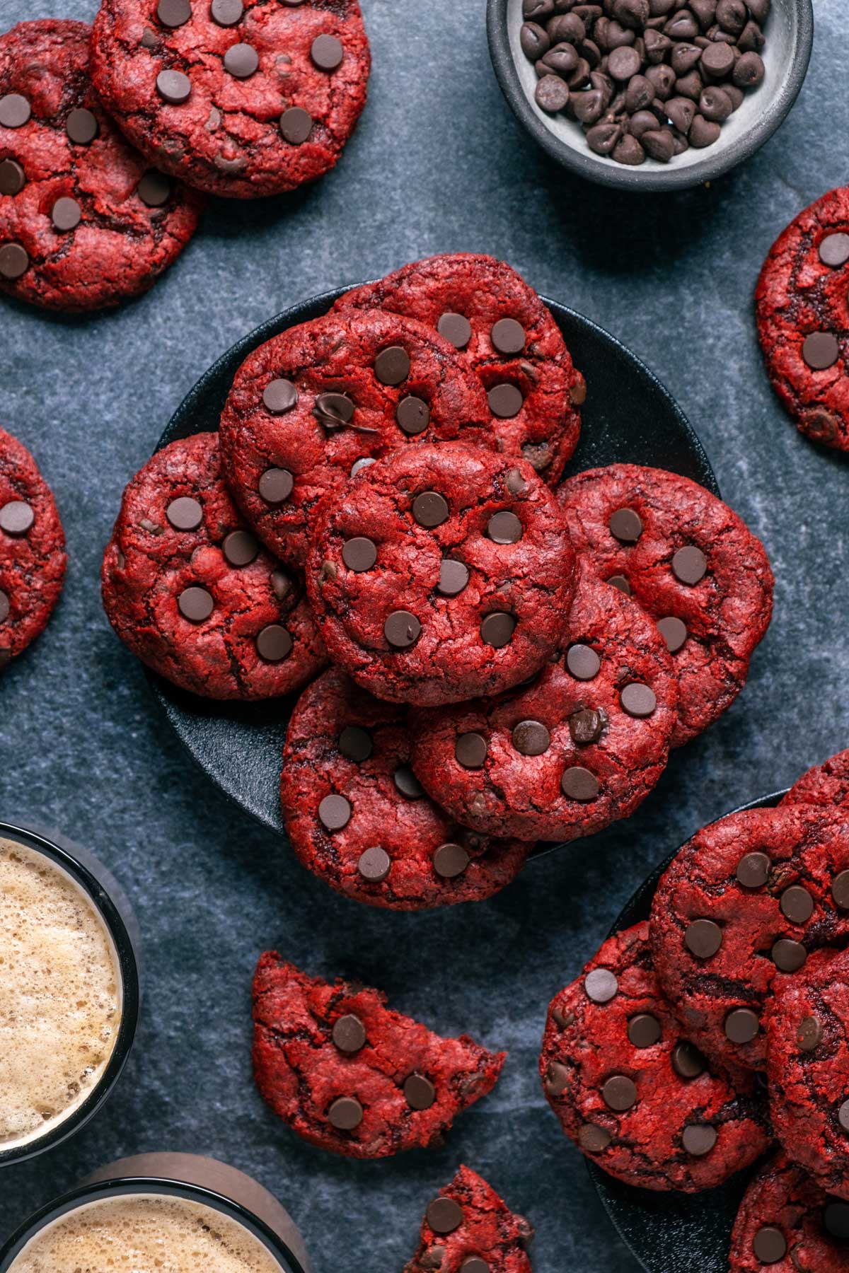 Vegan red velvet cookies stacked up on a black plate. 