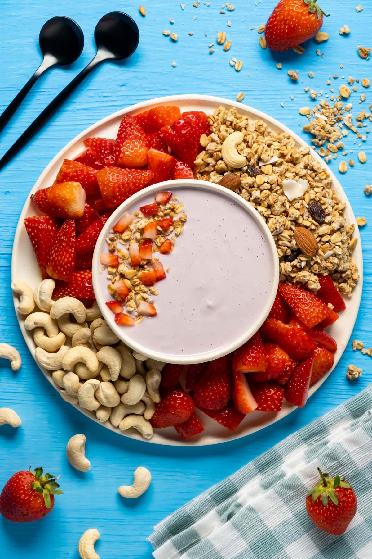 Vegan yogurt topped with granola and sliced strawberries. 