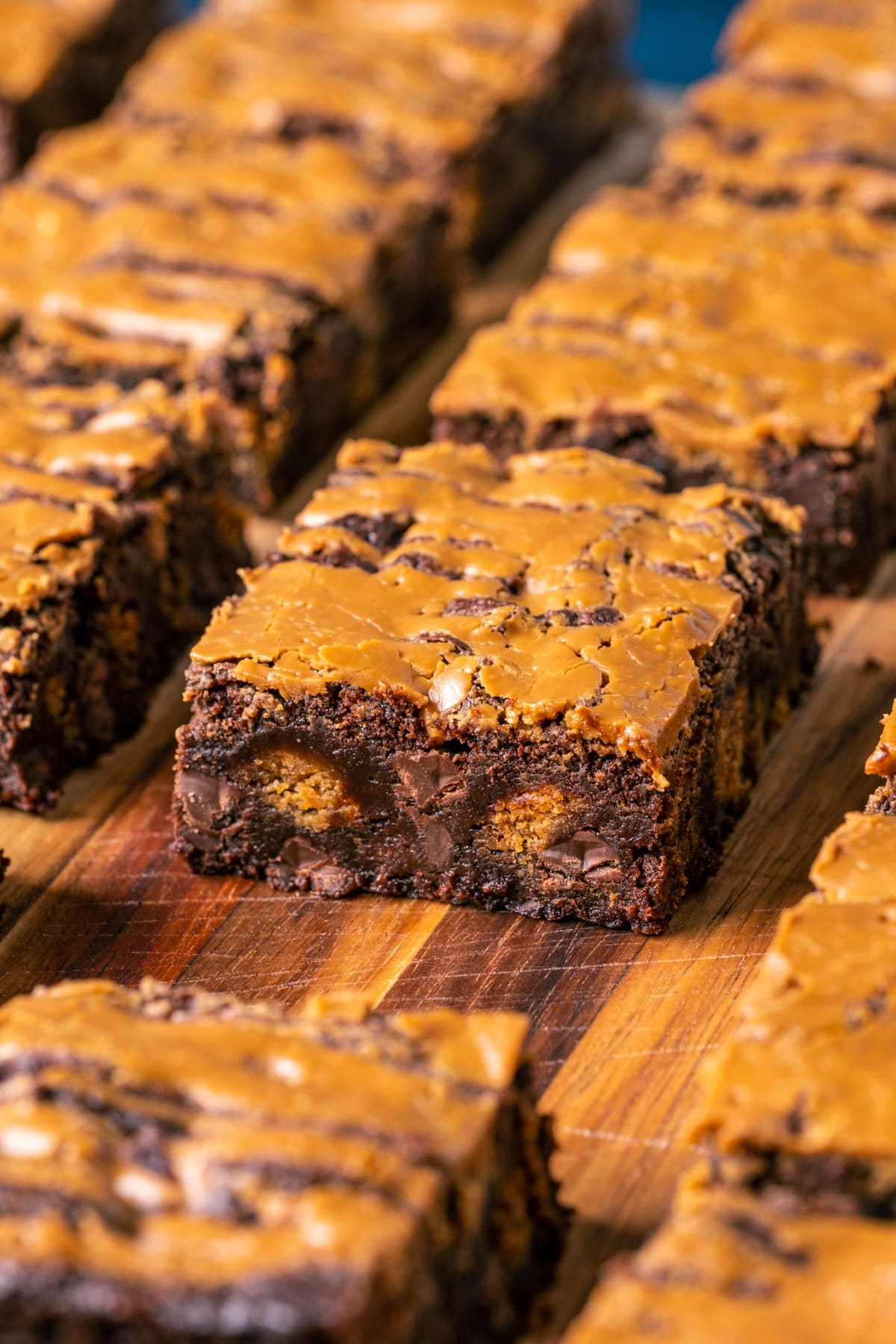 Vegan biscoff brownies sliced into squares on a wooden board.