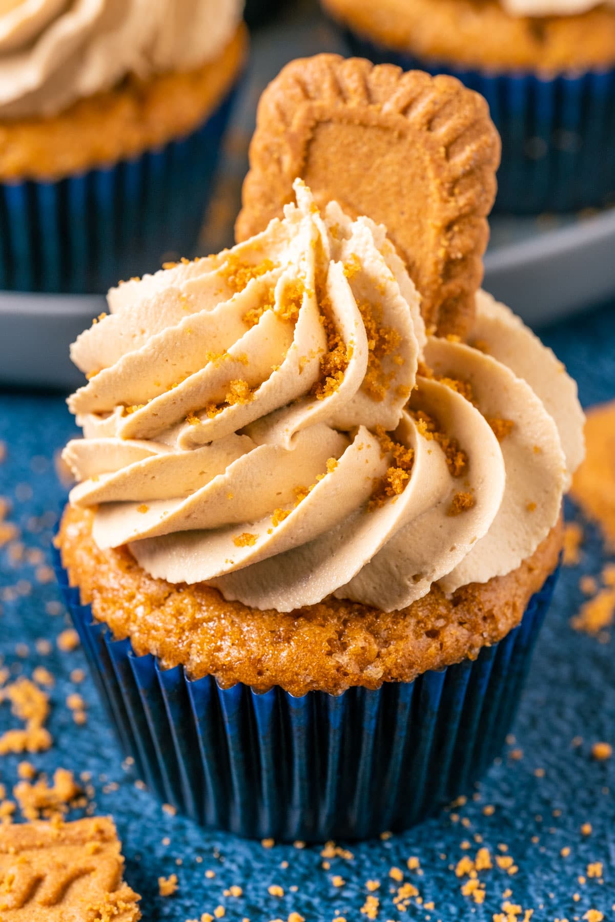 Vegan biscoff cupcake topped with frosting and biscoff cookies.