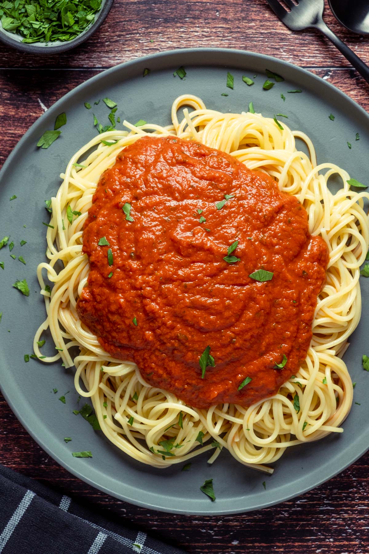 Vegan spaghetti sauce over spaghetti on a gray plate. 