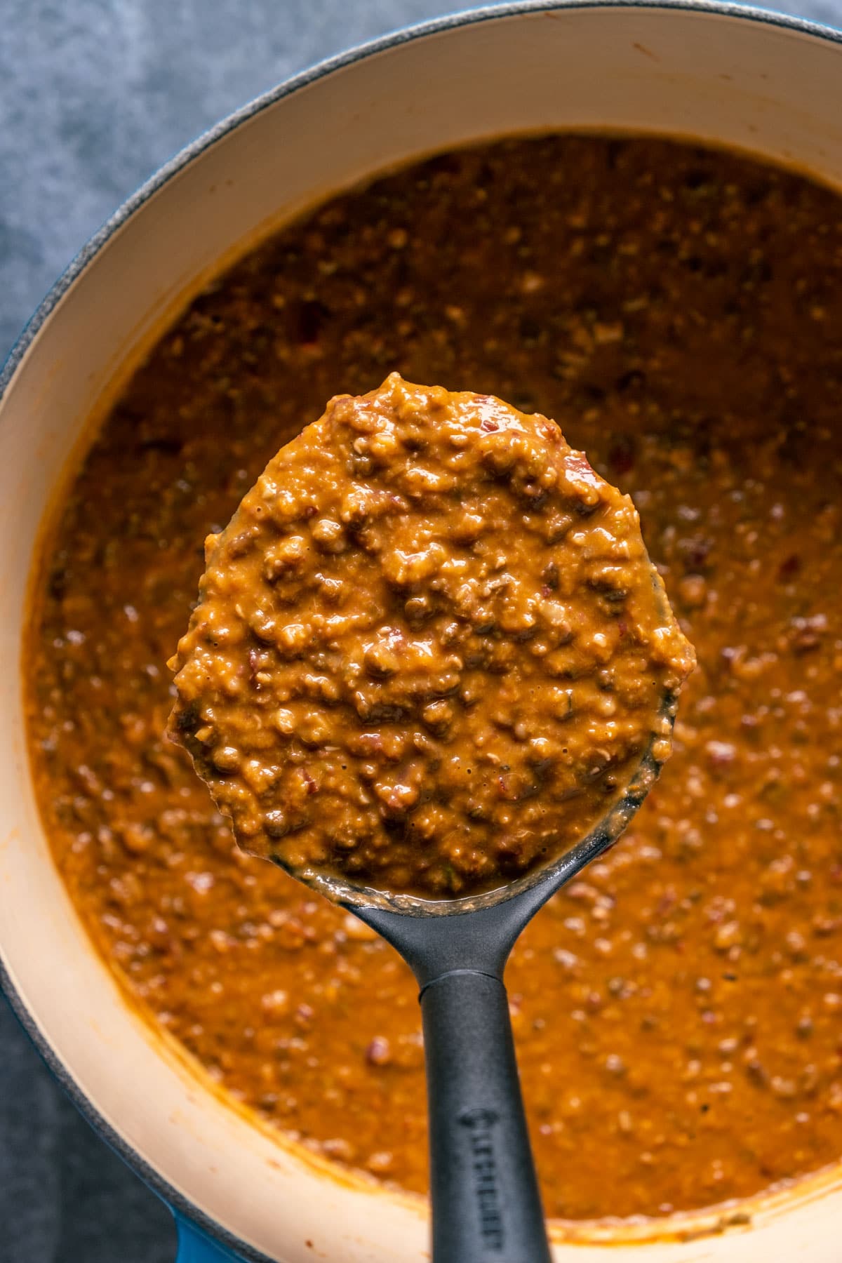 Dal makhani in a pot with a serving spoon.