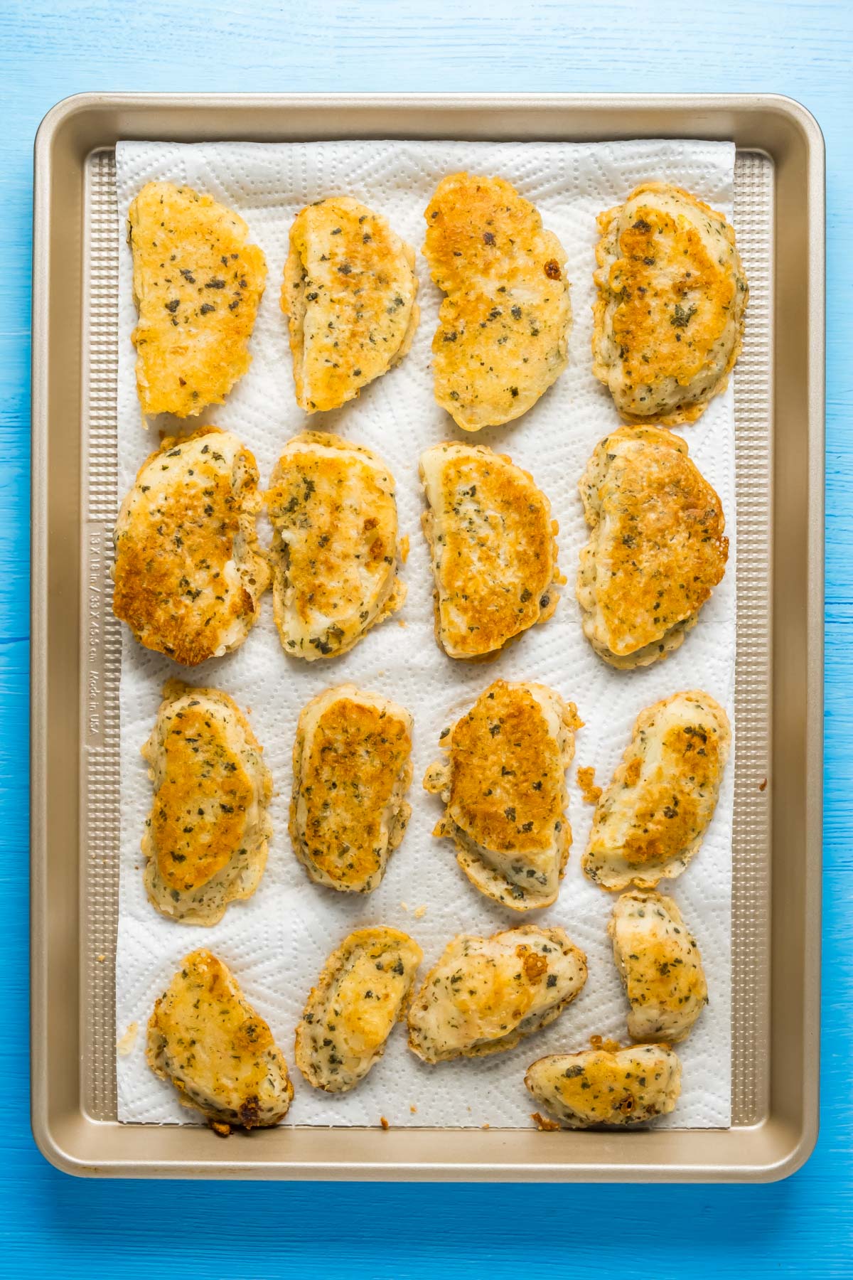 Fried vegan fish pieces on a tray lined with paper towels.