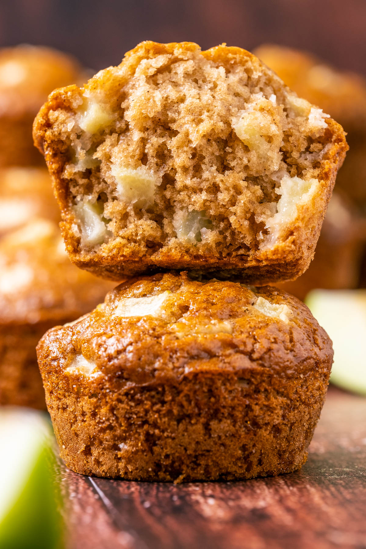 Stack of two apple muffins with the top muffin broken in half.