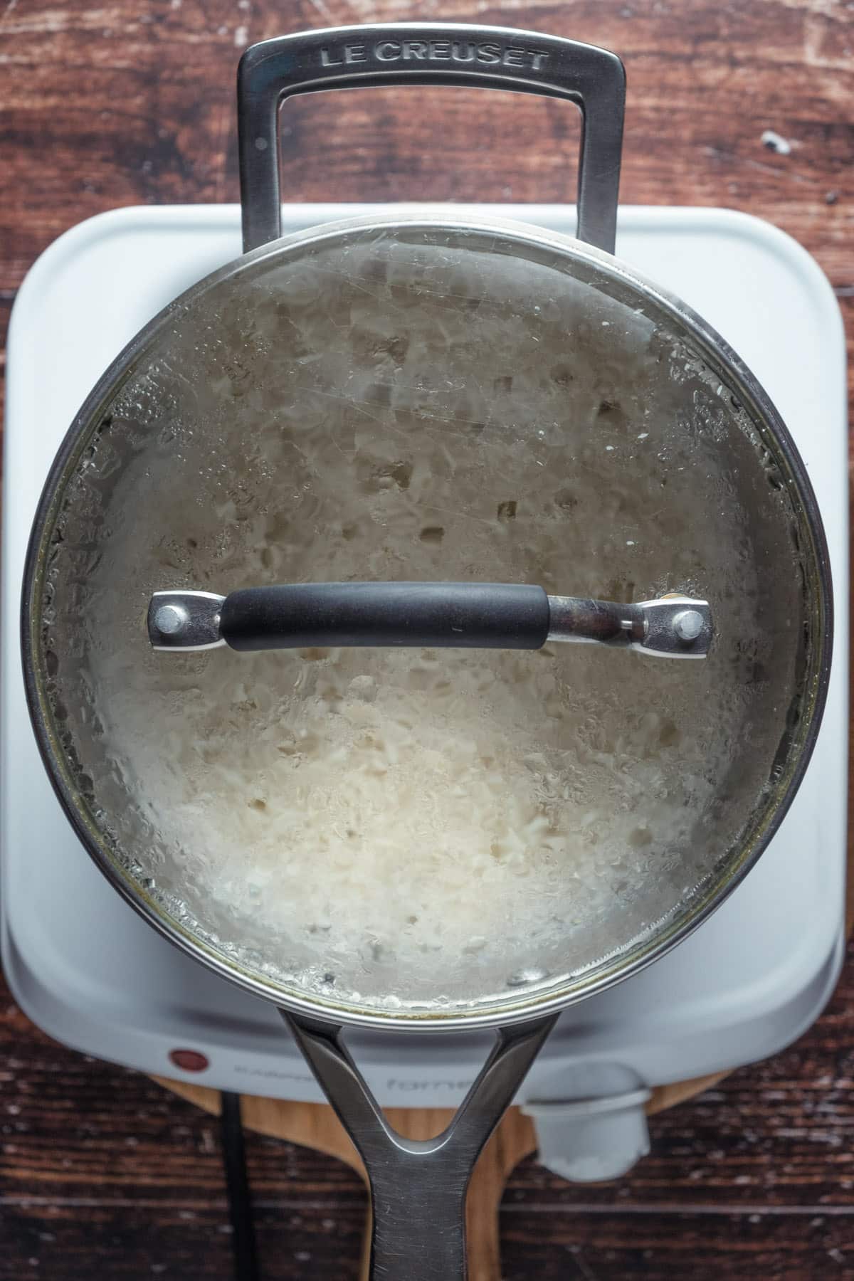 Basmati rice cooking in a pot with the lid on.