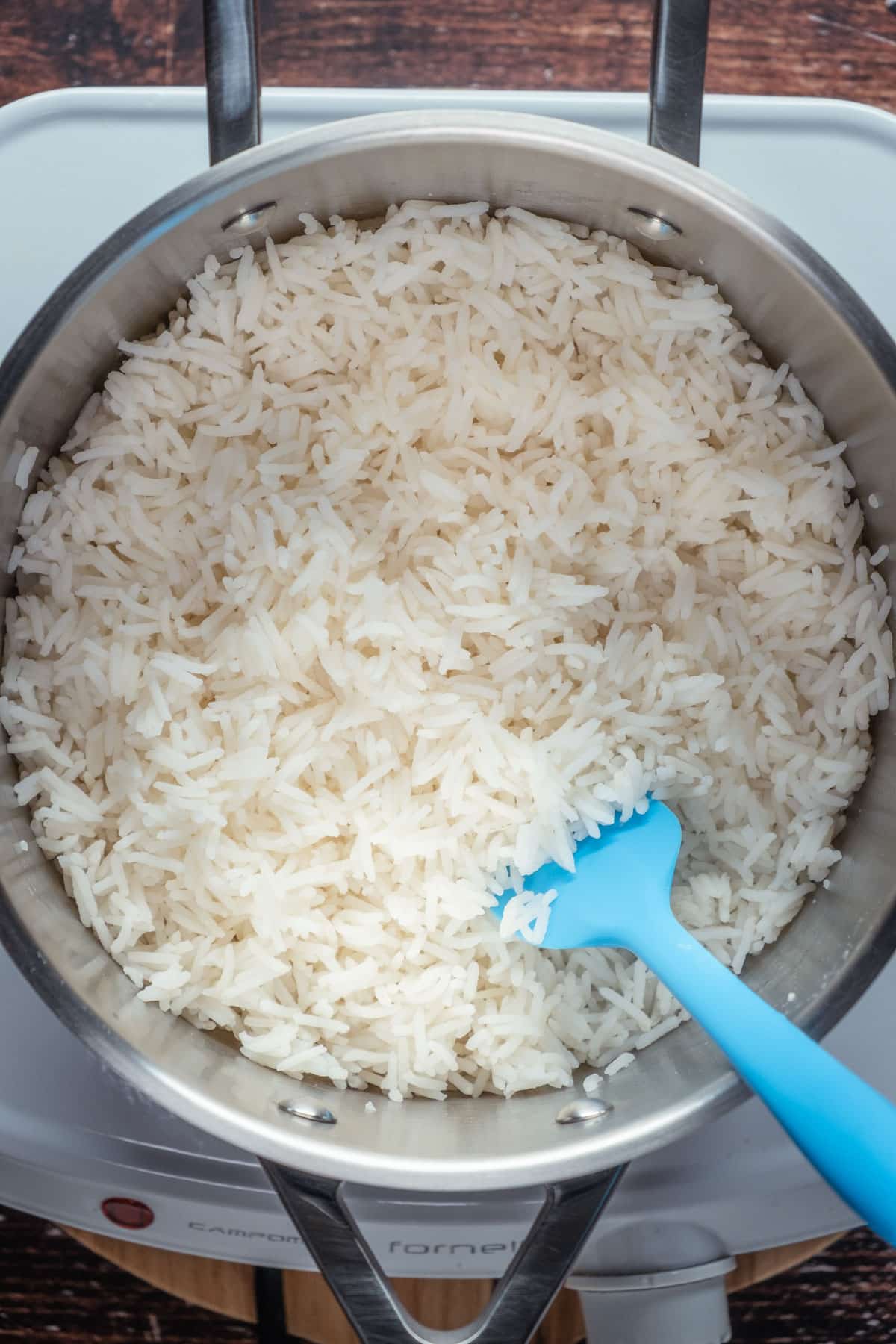 Fluffing cooked basmati rice with a rubber paddle.